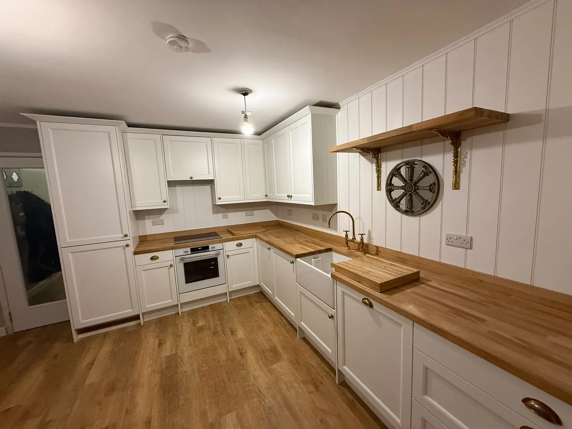 White shaker kitchen with timber worktops, open shelving and a Belfast sink