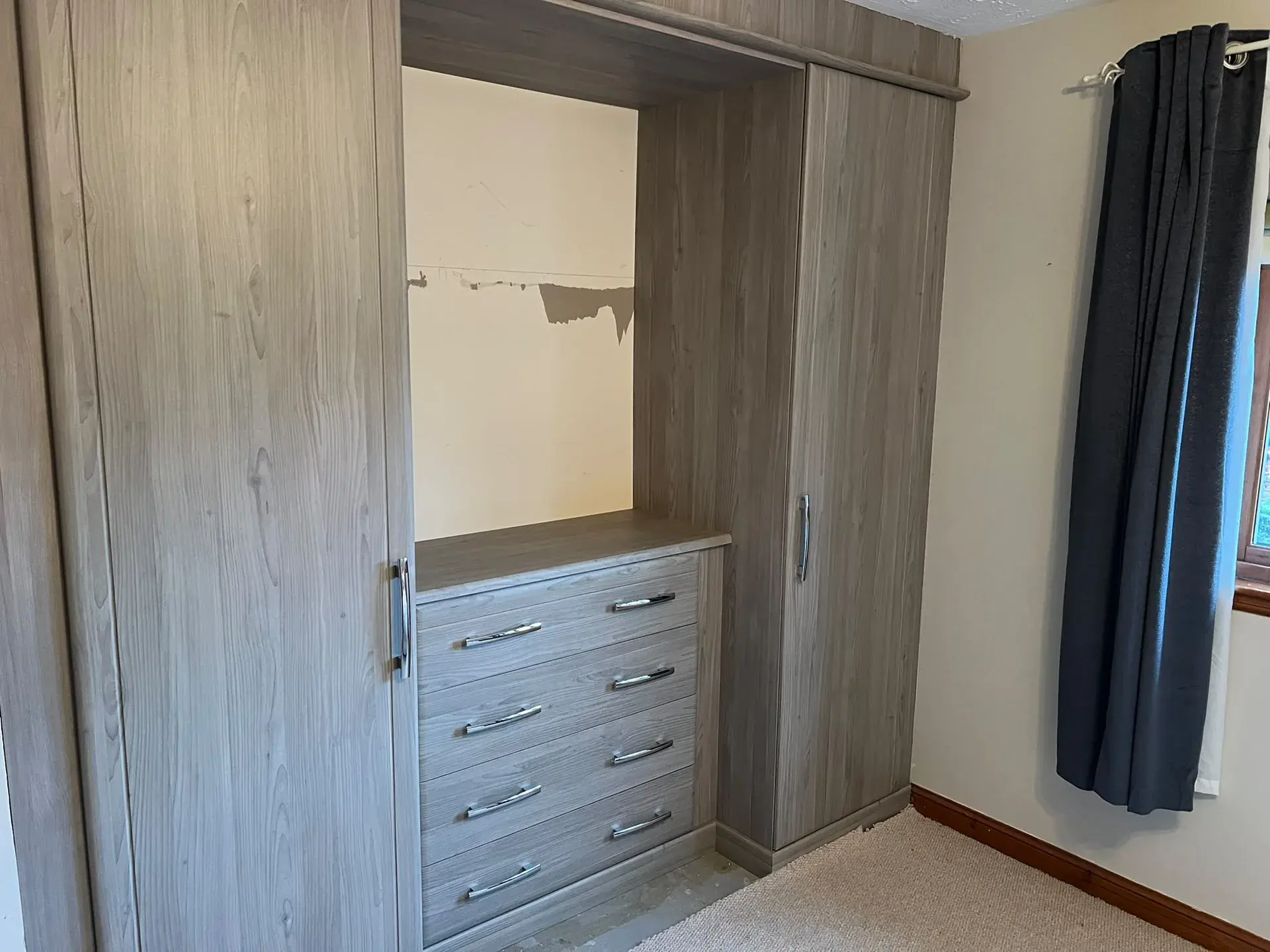 Fitted wardrobe with central drawers and an open recess
