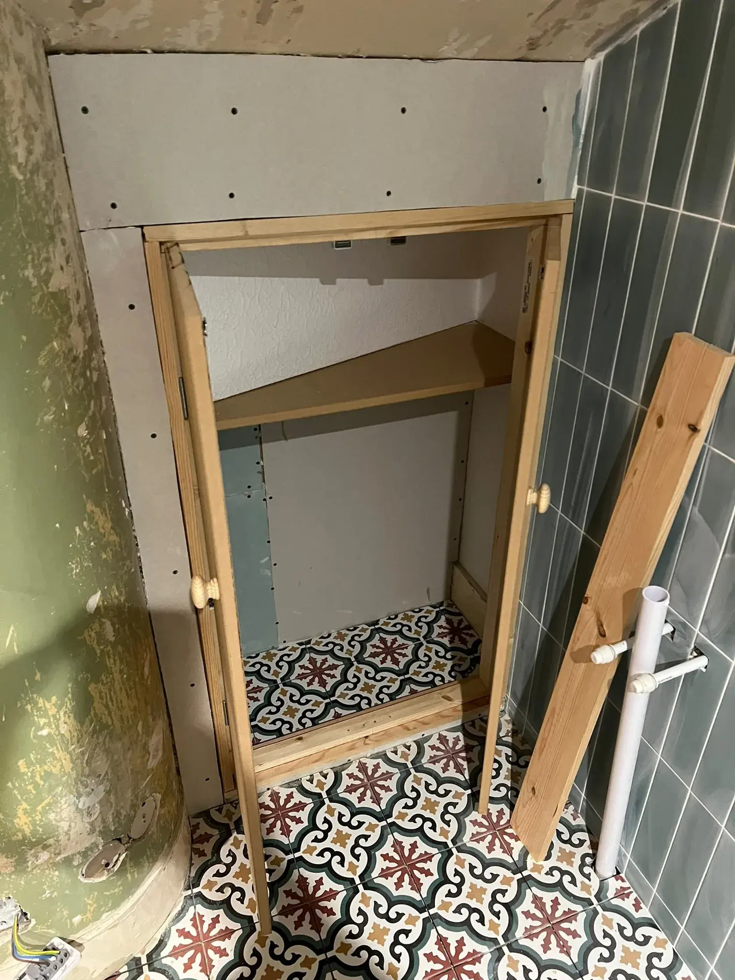 Door opening during joinery work beside patterned floor tiles
