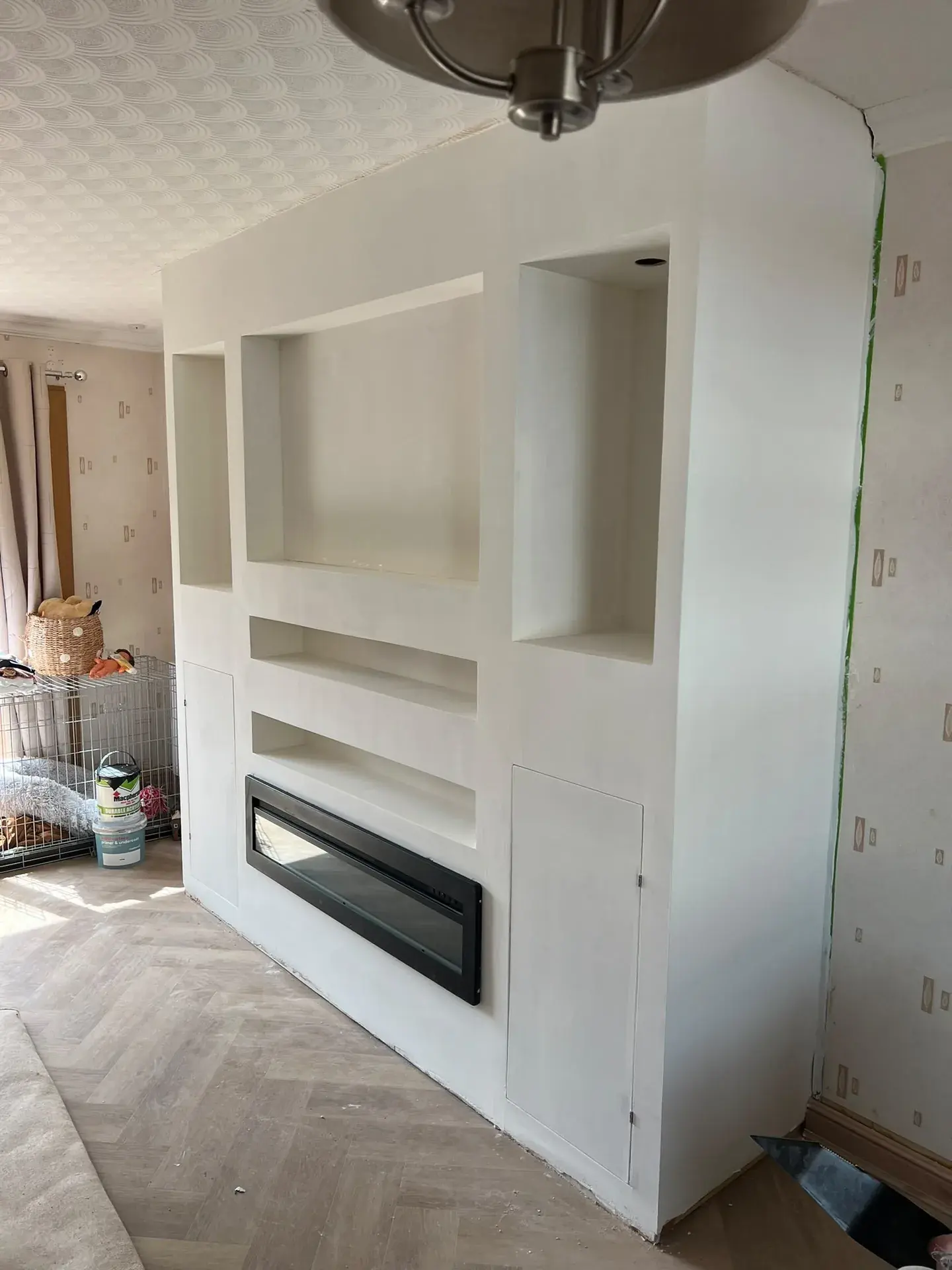 Finished white media wall with shelves and inset fireplace