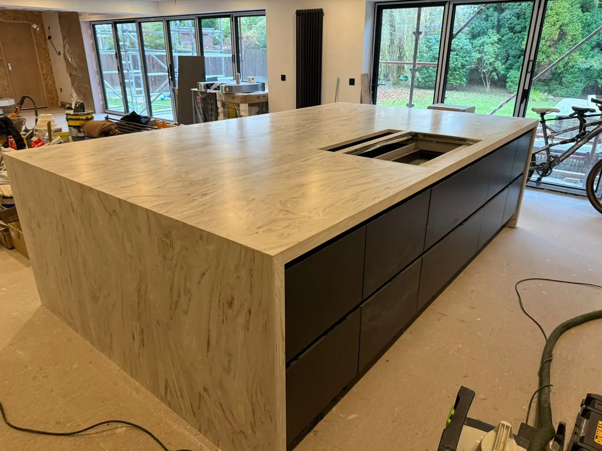 Island worktop with sink cut-out beside garden glazing